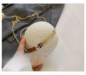Detailansicht der runden Abendtasche mit Perlenwebung und goldener Metallkette
