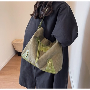 Detail of olive green corduroy tote bag with retro gold studs and long tassels decoration