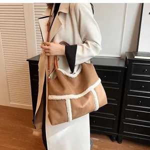 Detailed view of brown suede tote bag with white faux shearling trim and long shoulder strap