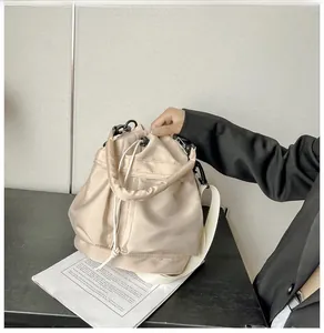 Macro shot of nylon bucket bag detailing beige fabric texture and black matte hardware