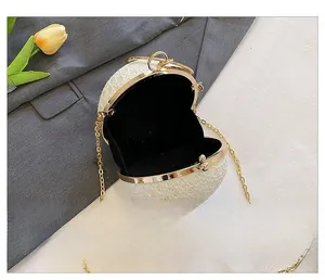 Detailansicht des schwarzen Innenfutters und der Goldkette der runden Perlenabendtasche