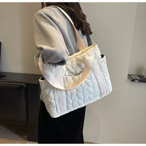Close-up of white quilted tote bag showing large capacity and herringbone pattern