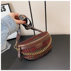 Détail du sac à carreaux avec chaîne dorée et bandoulière bohème présenté à la main