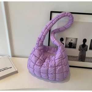 Macro detail of purple quilted cloud bag with padded texture and stitched strap design