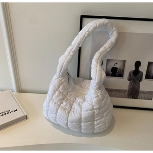 Detail of white quilted puffer bag showing square padding texture and nylon fabric