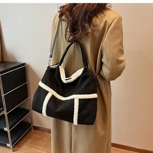Detailed back view of a black suede tote bag with white plush trim worn by a model