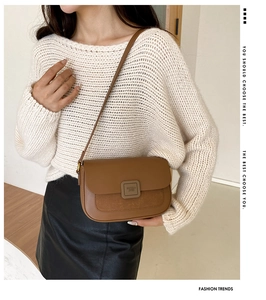 Brown patchwork crossbody bag with smooth and suede leather details on a cozy sweater