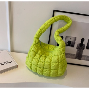 Close-up of lime green quilted puffy bag with a soft feather-like texture and zipper detail