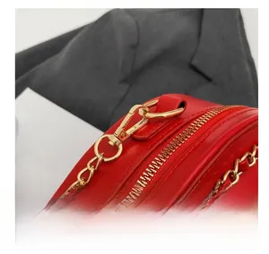 Macro shot of high-quality gold metal zipper and hardware hooks on a red heart handbag