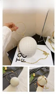 Detail der kugelrunden Abendtasche mit Glitzerpailletten und großem goldenem Griff