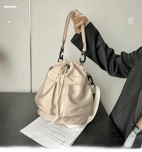 Close-up of nylon bucket bag with drawstring closure and wide fabric shoulder strap