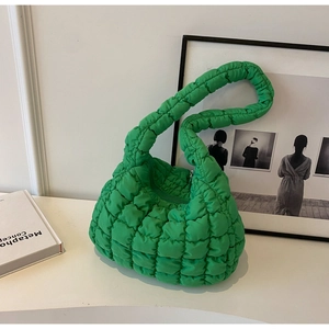 Detail of vibrant green quilted puff bag with textured cloud pleated fabric and zipper