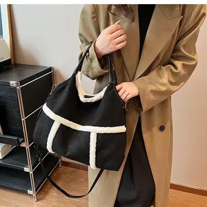 Detail of black canvas tote bag with white plush trim and leather handle on a beige trench coat