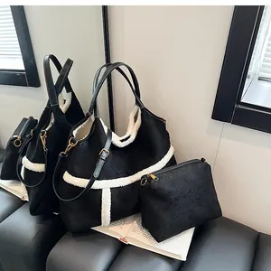 Detail of black suede tote bag with white faux shearling trim and matching pouch