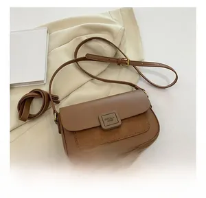 Detail of brown patchwork shoulder bag featuring suede texture and square metal buckle