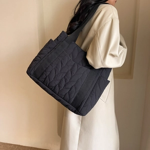 Black leaf quilted tote bag with wide shoulder strap for casual travel and work