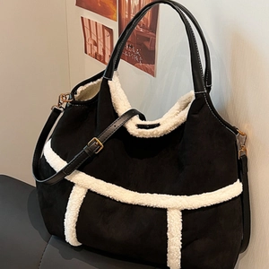 Black suede tote bag with white faux shearling trim and adjustable leather shoulder strap