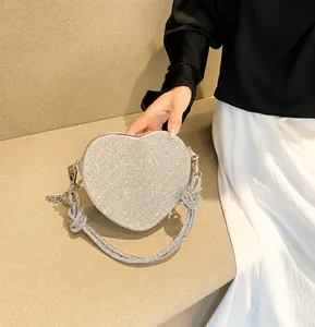 Dettaglio borsa a tracolla argentata a forma di cuore con strass e catena rimovibile
