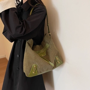 Retro dark green corduroy hobo bag with leather trim and gold buckles on a model