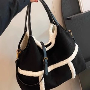 Large black suede tote bag with white shearling trim and adjustable shoulder strap