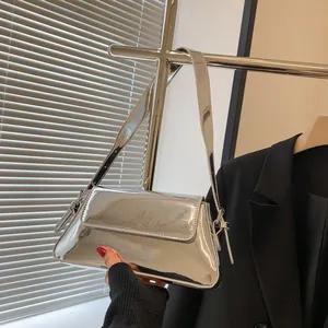 Close-up of metallic silver mirror finish baguette bag with wide shoulder strap