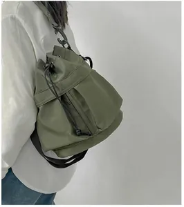 Detail view of army green nylon bucket bag with adjustable black woven drawstring and strap