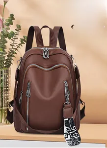 Detail of brown litchi pattern leather backpack with metal zippers and geometric strap