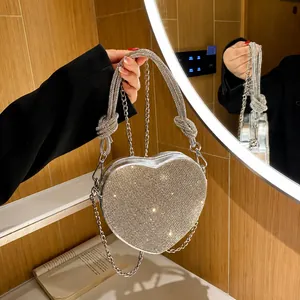 Vista macro della borsa da sera a cuore argento con strass scintillanti e tracolla