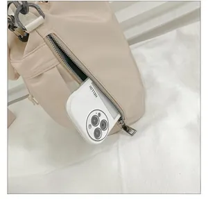 Detail of side zipper pocket on beige nylon bucket bag showing smartphone storage capacity
