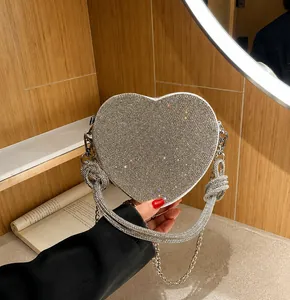 Dettaglio della borsa da sera a forma di cuore con strass argento e manico con nodo