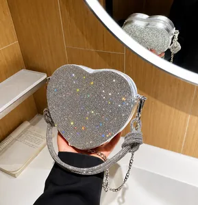 Dettaglio della borsa da sera a forma di cuore con strass argento e manico con nodo