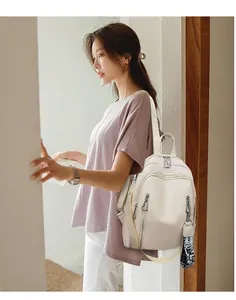 Detailed view of the soft white leather backpack with multi-zipper pockets and stylish straps