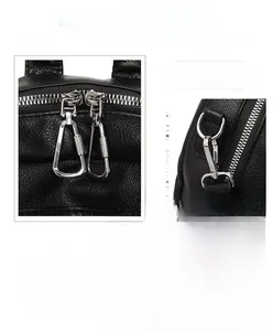 Close-up of black litchi grain leather texture and premium silver hardware of the backpack