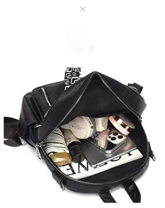 Top-down view of spacious interior of black soft leather backpack showing capacity for gadgets