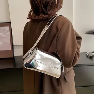 Silver mirror finish baguette bag shown in a stylish crossbody wear on a model