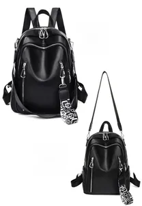 Detail of black leather backpack featuring dual vertical zippers and geometric woven strap