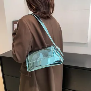 Chic metallic blue patent leather baguette bag shown as a crossbody on a model