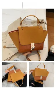 Detail of brown wing bag featuring suede flap and crocodile pattern texture