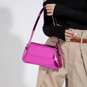 Detail of hot pink patent leather baguette bag with glossy mirror finish and wide strap