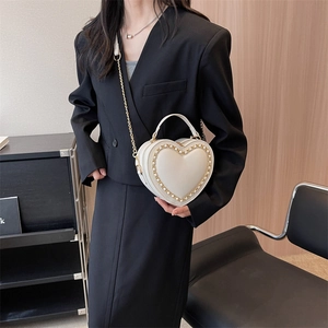 White heart-shaped crossbody handbag with gold chain strap and woven detail for women