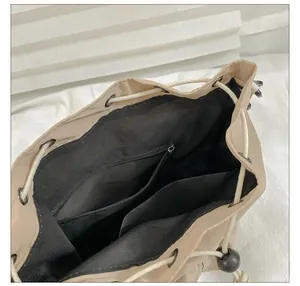 Interior view of beige nylon bucket bag showing zipper pocket and dual card compartments