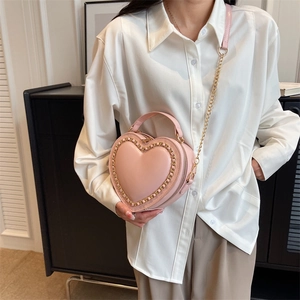 Pink heart-shaped crossbody bag with gold chain strap and smooth faux leather finish