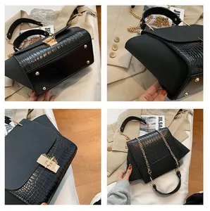 Macro view of black crocodile pattern leather bag with golden metal rotary lock