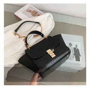 Detailed view of crocodile pattern faux leather handbag with gold chain strap and buckle