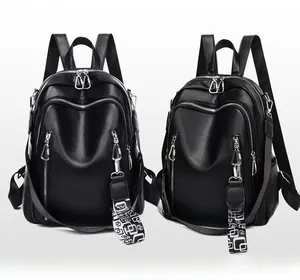 Detail of black soft leather backpack featuring standard and patterned wide shoulder straps