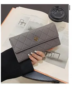 Detail of grey quilted long wallet featuring a golden camellia flower metal clasp