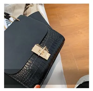 Close-up of black crocodile texture leather with elegant gold hardware lock detail