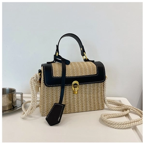 Dettaglio della borsa a tracolla in paglia beige con finiture nere e tracolla in corda bianca