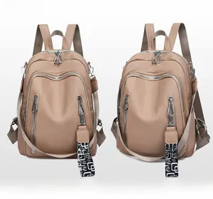Detail of khaki PU leather backpack featuring metal zippers and geometric pattern strap