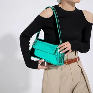 Close-up of metallic green mirror baguette bag with glossy finish and sleek shoulder strap